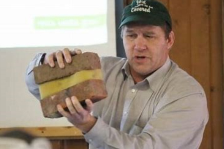 Jim Hoorman with demonstrating good soil structure with brick and sponge Port Clinton, Ohio 2019 man with thumbs up