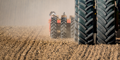 Tractor tilling dark farm land